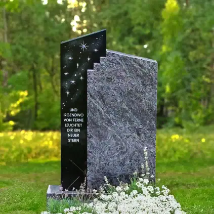 Heller Grabstein mit einem schwarzen Sternenhimmel-Design und eingravierten Zeilen, umgeben von weißen Blumen auf einem Friedhof, symbolisiert Hoffnung und Trost.