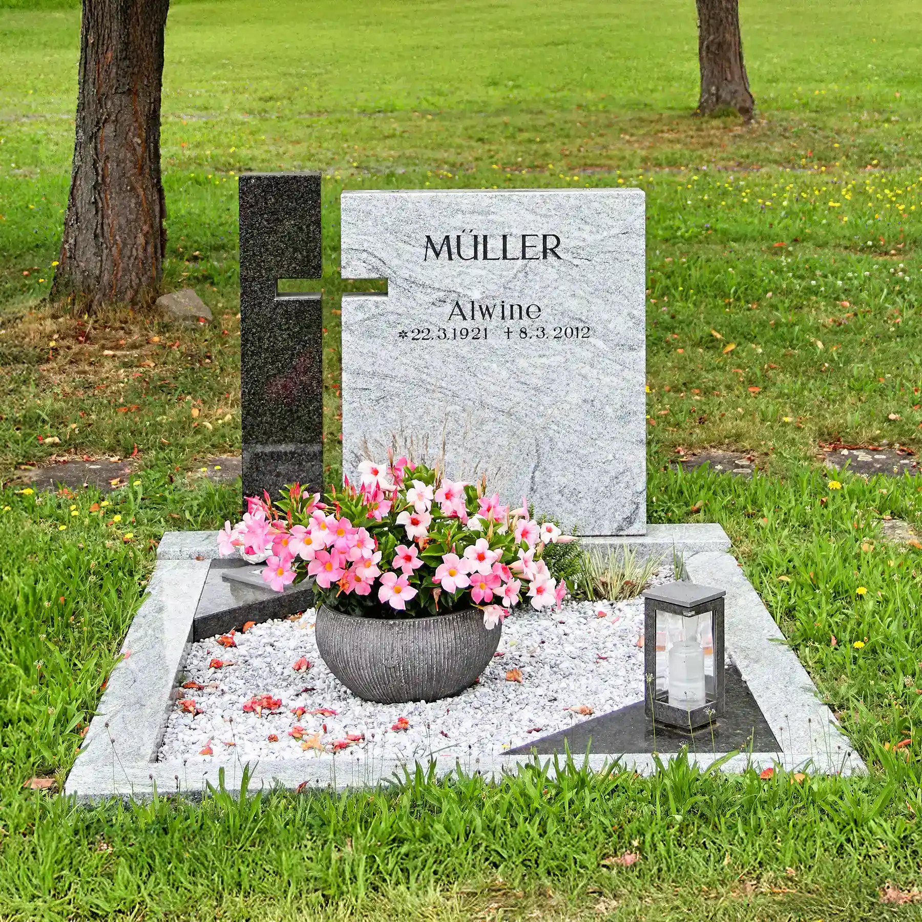 Grabstein mit Blumen und Kerze auf gepflegtem Friedhof, individuelles Grabstein-Design aus deutschem Steinmetzhandwerk für würdevolle Gedenkstätten.