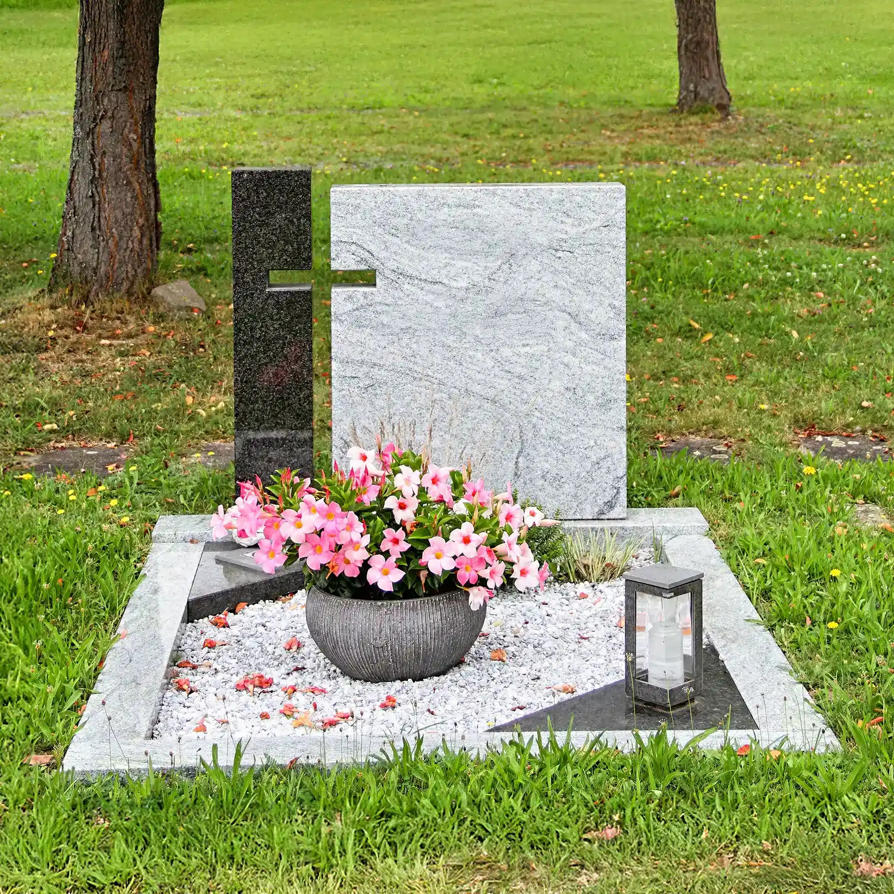 Hochwertiger Grabstein aus Granit mit Blumen und Laterne, gepflegte Grabgestaltung, langlebige Materialwahl für würdevolle Grabpflege, individuell gestaltbar für Begräbnisstätten, Bestattung.
