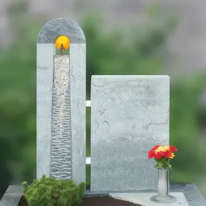 Familiengrabstein mit handgearbeitetem Lebensfluss-Relief und Glas-Sonnenornament, zweiteilig aus matt geschliffenem Granit